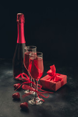 Valentine's day and birthday greeting card with champagne and heart candy on black.