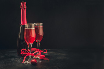 Valentine's day and birthday greeting card with champagne and heart candy on black.