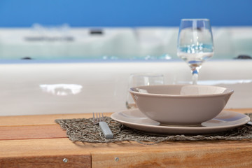 closeup on wooden frame around a hot tub with flatware for luxurious diners