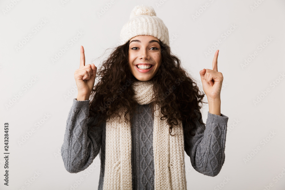 Poster cheerful young woman wearing winter scarf standing