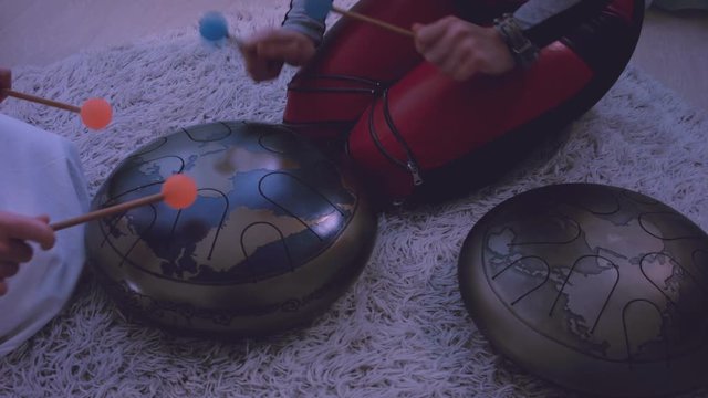 Young womеn playing the happy drum at home. 