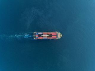 Aerial top view container ship at sea port and crane bridge loading container for logistics import...