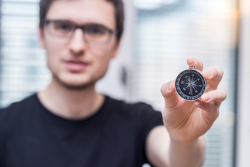 Young freelancer with compass holding in hand