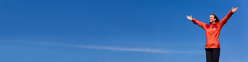 Woman Celebrating Arms Raised In Blue Sky Panorama