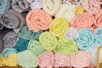 Pile of vibrant colorful rolled up fleece textile. Fabric for toys design