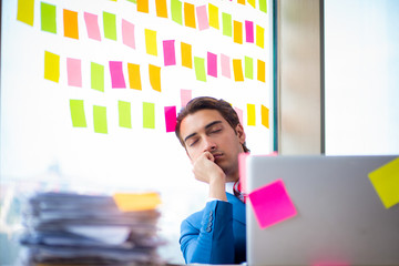 Young handsome employee with many conflicting priorities   