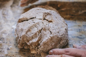 A piece of dough on the table, flour everywhere