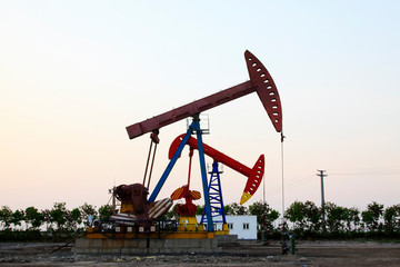 Crank balanced beam pumping unit in Jidong oilfield sunset scenery, closeup of photo