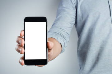 Hand showing black smartphone on gray background