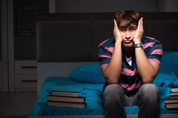 Obraz premium Young handsome student preparing for exams at night