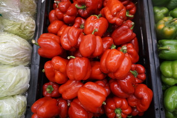 Red sweet bell peppers on black tray.
