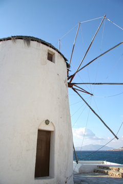 Traditional whitewashed wildmill on the hillside above Mykonos town, Cyclades, Greece.