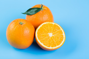 Orange slice. Fresh orange and half orange on blue background.