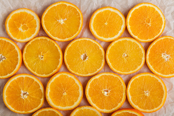 Abstract background with citrus orange slices on parchment paper. Close up. Top view. Studio photography.