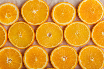 Abstract background with citrus orange slices on parchment paper. Close up. Top view. Studio photography.