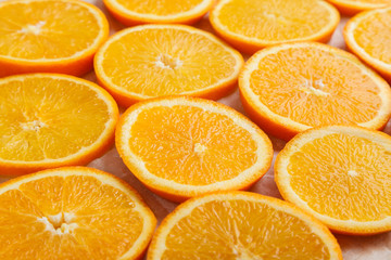 Abstract background with citrus orange slices on parchment paper. Close up. Top view. Studio photography.