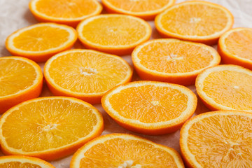 Abstract background with citrus orange slices on parchment paper. Close up. Top view. Studio photography.