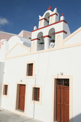 Fototapeta premium Bell tower of a traditional whitewashed church, Oia, Santorini, Greece.