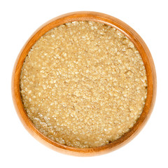 Homemade tahini, sesame paste, in wooden bowl. Brown condiment made of ground hulled sesame seeds. Dip or major ingredient in hummus, baba ghanoush and halva. Food photo closeup, on white background.