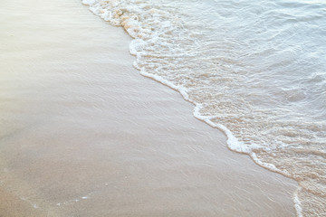 Sand beach of a seashore with a wave