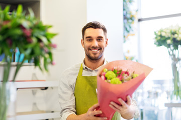 small business, sale and floristry concept - happy smiling florist with bunch at flower shop