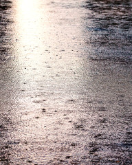 Rain drop on surface of water in puddle. Rainy day.