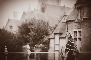 young girl in red sweater at streets of Bruges. Belgium, Atumn season Image in sepia color style