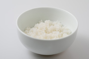 Rice in a white bowl on white background