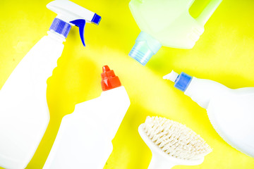 Cleaning concept with different cleaning supplies, on bright yellow background top view, copy space banner