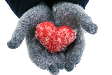 Female hands in woolen gloves holding red woolen heart with snowflakes isolated