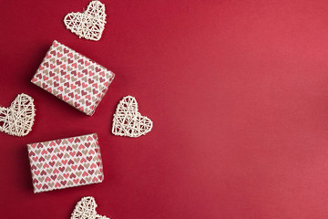 Obraz na płótnie Canvas Gift boxes with hearts and copy space on red background. Valentine's day concept.