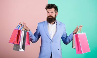 Enjoy shopping black friday. Hipster shopping with discount. Man bearded hipster businessman formal suit carry paper shopping bags. Ready for holiday. Buy gifts for everyone. Buy gifts in advance