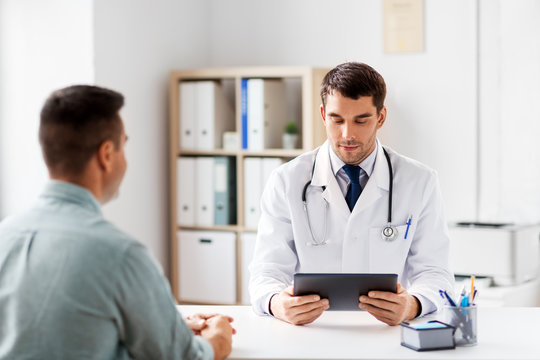 Medicine, Healthcare And Technology Concept - Doctor With Tablet Pc Computer And Male Patient At Medical Office In Hospital