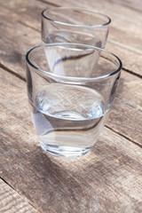 Glasses of water on a wooden table.