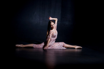 Fototapeta na wymiar Beautiful ballerina sat on the splits close-up