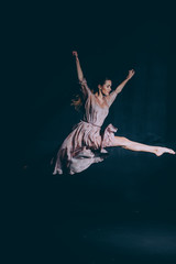 Fototapeta na wymiar Ballerina on a black background make a jump