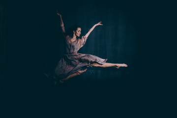 Ballet dancer in a jump on a black background