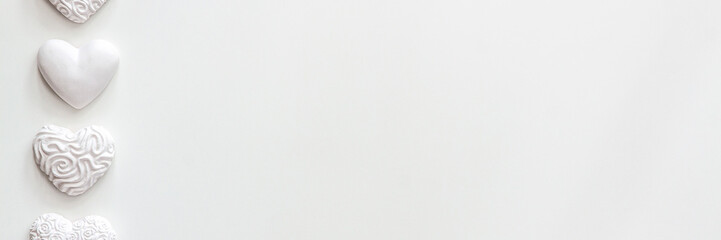 White background copy space with space for text. Valentine's panoramic background with white hearts arranged in a row. A photo in a high key