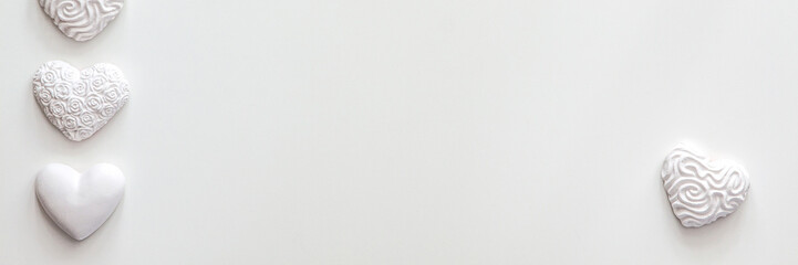 White background copy space with space for text. Valentine's background with white hearts arranged in a row. A photo in a high key. Panoramic real photo
