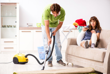 Husband helping leg injured wife in housework