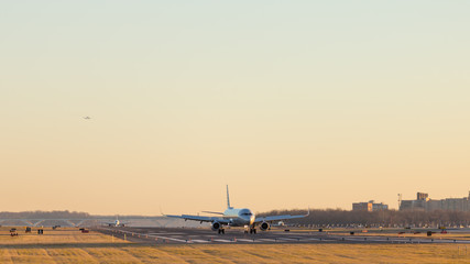 Fototapeta na wymiar Aircraft taking off and landing at Ronald Reagan Washington National Airport at sunset
