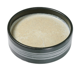 Cream soup in the black bowl. Isolated on white background.