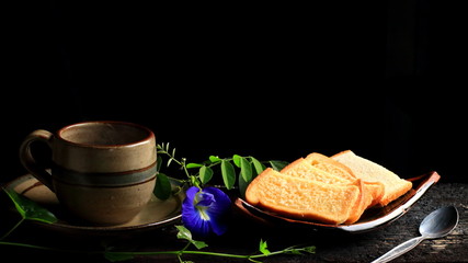 Bread and cup coffee on a dark background