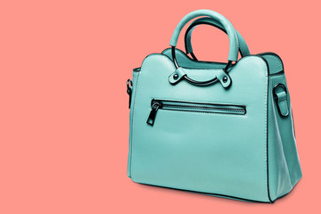 turquoise women bag with beautiful accessories, on the background color pantone, with a shadow © aneduard