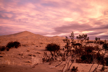 Fototapeta na wymiar Red glowing sky reflected on the sand dunes, Kelso Sand Dune, Mojave National Preserve, California