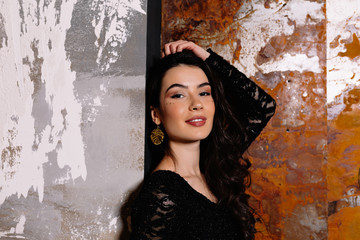 Close up portrait of beautiful elegant caucasian woman with long dark hair and bif eyes posing during photoshoot on dark background with wonaderl smile. Holiday, birthday, party