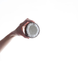 Woman holding fresh delicious coconut against white surface