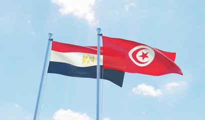Tunisia and Egypt, two flags waving against blue sky. 3d image
