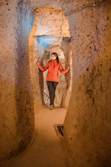 Obraz na płótnie Canvas Young tourist woman explore ancient Derinkuyu underground cave city