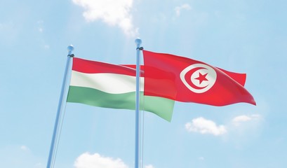 Tunisia and Hungary, two flags waving against blue sky. 3d image